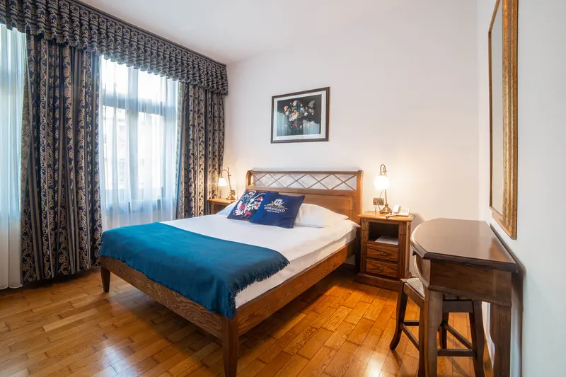 Sypialnia z łóżkiem i niebieską narzutą — Apartament Prestige, Hornigold