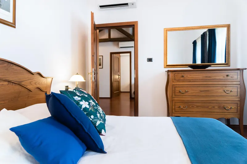 Łóżko, lustro i drewniana komoda — Apartament Prestige Deluxe, Hornigold